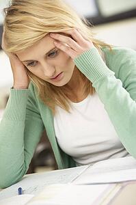 Stressed Female Teenage Student Studying In Classroom