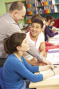 Teenage Students Studying In Classroom With Tutor
