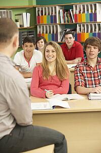 Teenage Students Studying In Classroom With Tutor