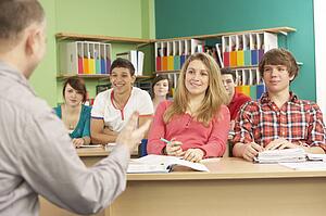 Teenage Students Studying In Classroom With Tutor