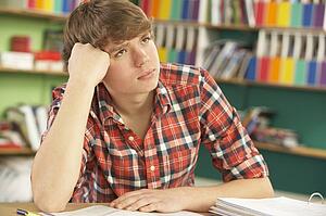 Teenage Male Student In Working In Classroom