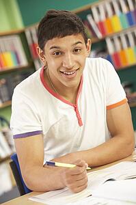 Teenage Male Student In Working In Classroom