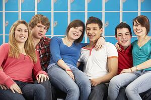 Teenage Students Relaxing By Lockers In School