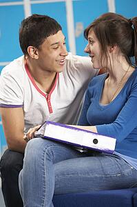 Teenage Students Relaxing By Lockers In School