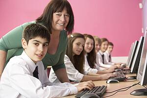 Teenage Students In IT Class Using Computers In Classroom With T