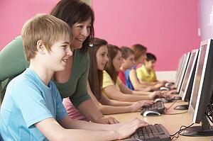 Teenage Students In IT Class Using Computers In Classroom With T