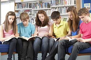 Teenage Students In Library Reading Books