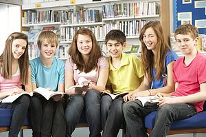 Teenage Students In Library Reading Books