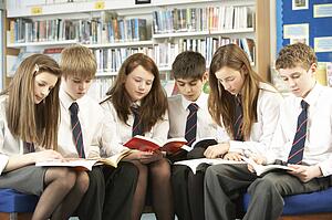 Teenage Students In Library Reading Books