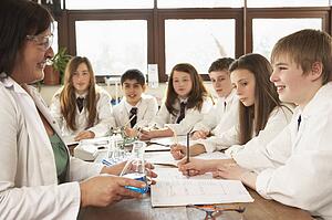 Group Of Teenage Students In Science Class With Tutor