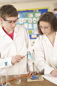 Male And Female Teenage Student In Science Class With Experiment