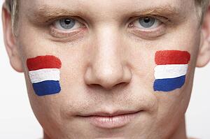 Young Male Sports Fan With Dutch Flag Painted On Face