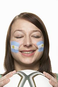 Young Female Football Fan With Argentinian Flag Painted On Face