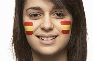 Young Female Sports Fan With Spanish Flag Painted On Face