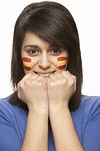 Young Female Sports Fan With Spanish Flag Painted On Face
