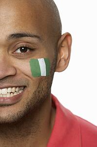 Young Male Sports Fan With Nigerian Flag Painted On Face