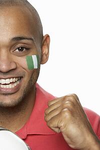 Young Male Football Fan With Nigerian Flag Painted On Face