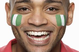 Young Male Sports Fan With Nigerian Flag Painted On Face