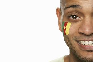 Young Male Sports Fan With Cameroon Flag Painted On Face