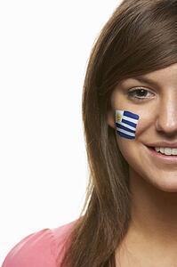 Young Female Sports Fan With Uruguayan Flag Painted On Face