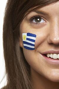 Young Female Sports Fan With Uruguayan Flag Painted On Face