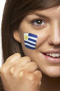 Young Female Sports Fan With Uruguayan Flag Painted On Face