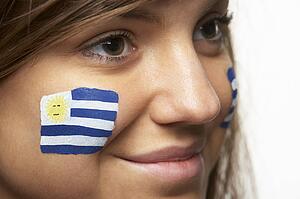 Young Female Sports Fan With Uruguayan Flag Painted On Face