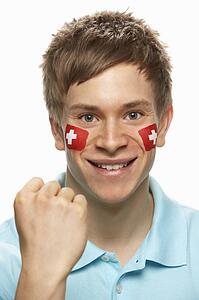 Young Male Sports Fan With Swiss Flag Painted On Face