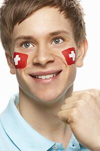 Young Male Sports Fan With Swiss Flag Painted On Face