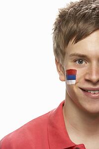 Young Male Sports Fan With Serbian Flag Painted On Face
