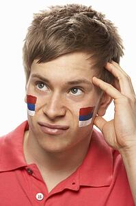 Disappointed Young Male Sports Fan With Serbian Flag Painted On Face