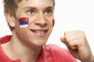 Young Male Football Fan With Serbian Flag Painted On Face