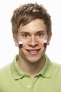 Young Male Sports Fan With Slovakian Flag Painted On Face