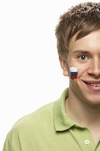 Young Male Sports Fan With Slovakian Flag Painted On Face