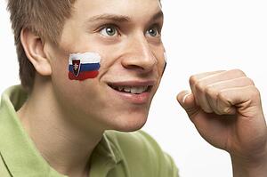 Young Male Sports Fan With Slovakian Flag Painted On Face