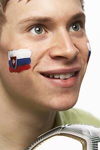 Young Male Football Fan With Slovakian Flag Painted On Face
