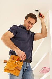 Electrician Installing Light Fitting In Home
