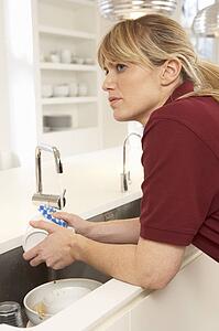 Cleaner Working In Domestic Kitchen