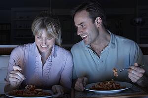 Couple Enjoying Meal Whilst Watching TV