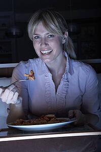 Woman Enjoying Meal Whilst Watching TV