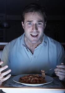Man Enjoying Meal Whilst Watching TV
