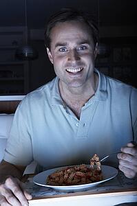 Man Enjoying Meal Whilst Watching TV