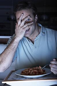 Frightened Man Enjoying Meal Whilst Watching TV