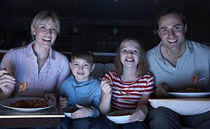 Family Enjoying Meal Whilst Watching TV