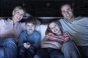 Family Watching TV On Sofa Together