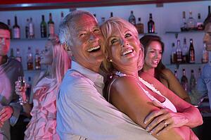 Senior Couple Having Fun In Busy Bar