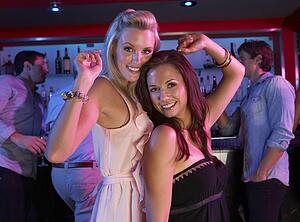 Two Young Women Having Fun In Busy Bar