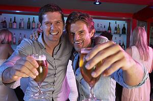 Two Young Men Having Fun In Busy Bar