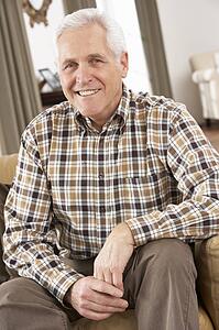 Senior Man Relaxing In Chair At Home