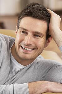 Young Man Relaxing In Chair At Home